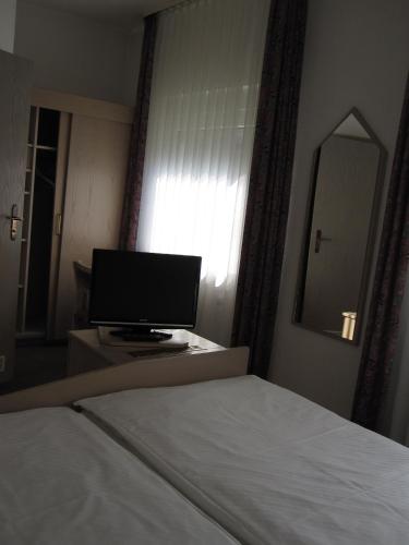 邁恩的住宿－麥飛德霍夫酒店，一间卧室,配有一张床和一张书桌上的电脑显示器