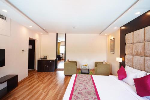 a hotel room with a bed and two chairs at Spectrum Resort, Spa & Residences in Udaipur