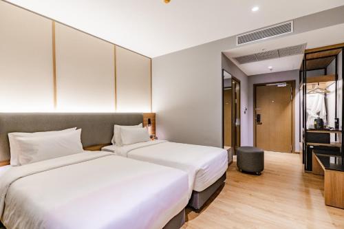 a hotel room with two beds and a television at Best Western Chatuchak in Bangkok