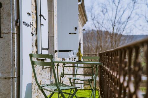 a table and chairs on a balcony with a window at Magnifique Appartement Climatisation Parking Gratuit in Saint-Jean-le-Centenier