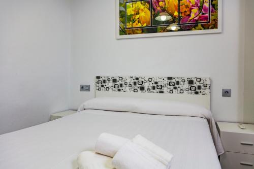 1 dormitorio con 1 cama blanca y 2 toallas blancas en Apartment Triana en Sevilla