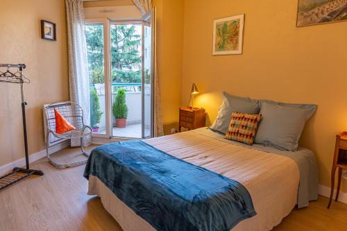 une chambre avec un grand lit et une fenêtre dans l'établissement Parc Blandan - T2 calme lumineux et bien situé., à Lyon