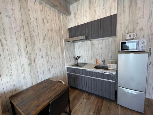 a kitchen with a white refrigerator and a wooden floor at WOLF PACK apartment 1002 in Osaka