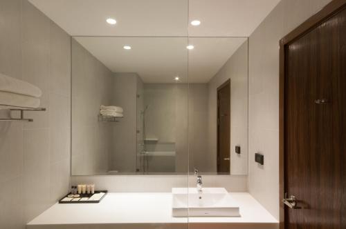 a bathroom with a sink and a large mirror at Best Western Chatuchak in Bangkok