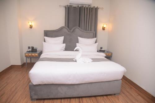 a bedroom with a large bed with a swan on it at The Rich Hotel & Apartments in Lahore