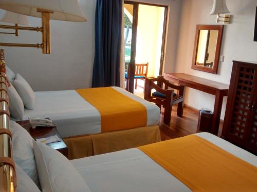a hotel room with two beds and a desk at Casa Cantarranas in Tehuacán