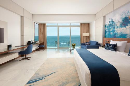 a hotel room with a bed and a view of the ocean at Royal M Al Aqah Beach Resort by Gewan in Al Aqah