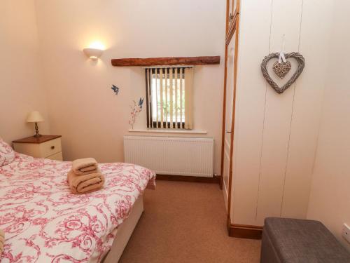 a bedroom with a bed and a heart on the wall at The Hayloft in Keswick