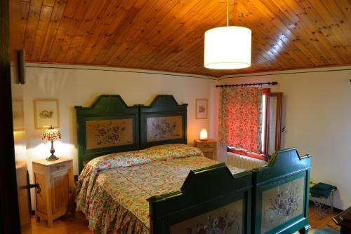 1 dormitorio con cama y techo de madera en B&B Casa di Campagna, en Miane