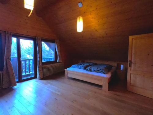 a bedroom with a bed in a room with windows at Lodge Tatras in Veľká Lomnica