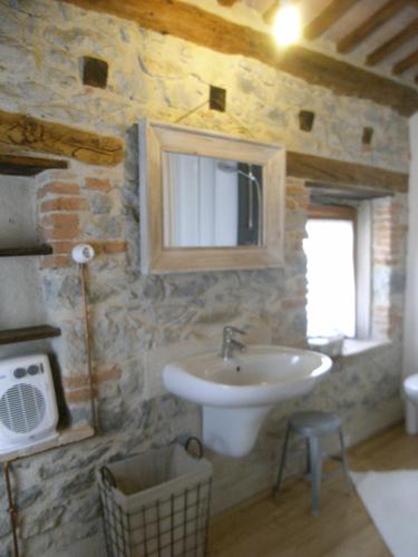 a bathroom with a sink and a stone wall at Agriturismo Casa di Campagna in Miane