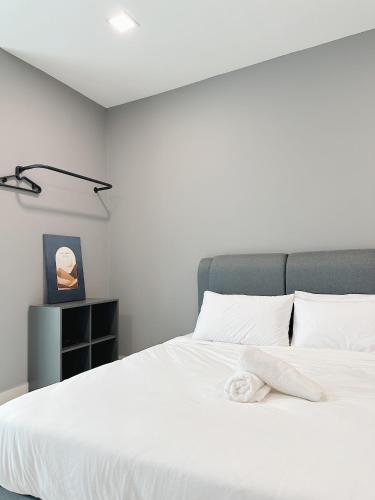 a bedroom with a white bed with a towel on it at Atria SOFO Suites By Stay In in Petaling Jaya