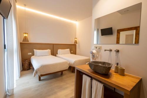 a bathroom with two beds and a sink in a room at Play Hotel Ibiza - Adults Only in Ibiza Town