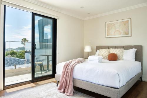 a bedroom with a large bed and a balcony at Retreat on Darling - Harbour Views 3 Bed in Sydney