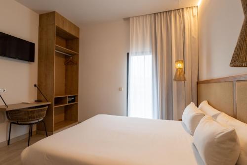 a bedroom with a large white bed and a desk at Play Hotel Ibiza - Adults Only in Ibiza Town
