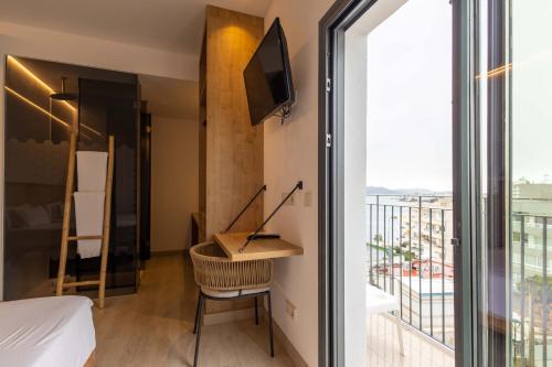 a room with a bed and a desk and a window at Play Hotel Ibiza - Adults Only in Ibiza Town