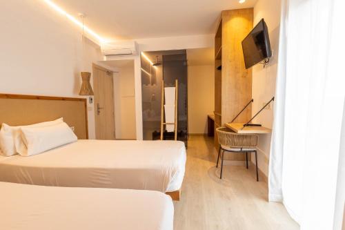 a hotel room with two beds and a desk at Play Hotel Ibiza - Adults Only in Ibiza Town