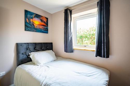 Habitación pequeña con cama y ventana en Fantastic and Sleek 3BD Home Wrington Bristol, en Bristol