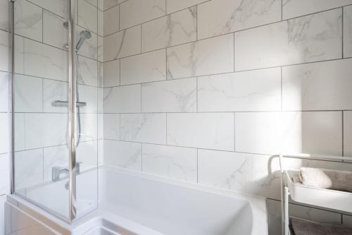 a white bathroom with a tub and a shower at Fantastic and Sleek 3BD Home Wrington Bristol in Bristol