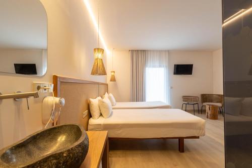 a hotel room with two beds and a bath tub at Play Hotel Ibiza - Adults Only in Ibiza Town