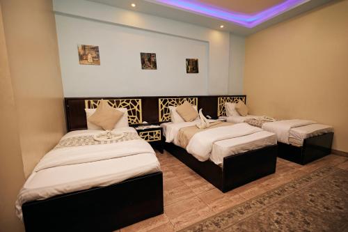 a room with three beds in a room at رويال ابو الوفا in Suwhaj