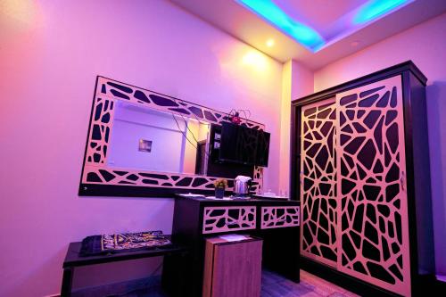 a bathroom with a mirror and a purple wall at رويال ابو الوفا in Suwhaj