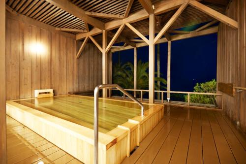einen Pool in einem Holzhaus mit Holzterrasse in der Unterkunft Shimoda Tokyu Hotel in Shimoda