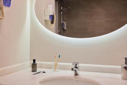 a bathroom sink with two toothbrushes and a mirror at TUI MAGIC LIFE Sarigerme in Sarigerme
