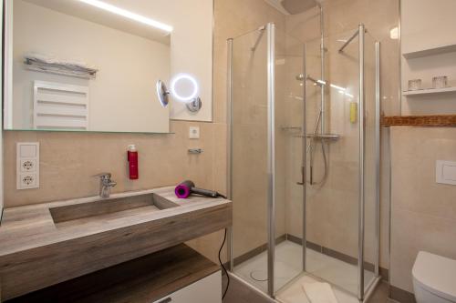 a bathroom with a sink and a shower at Hotel Achterum Greetsiel in Greetsiel