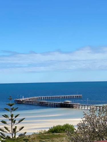 a pier in the ocean next to a beach at Views on Hughes in Port Moonta