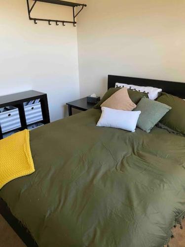 a green bed with pillows on it in a bedroom at Views on Hughes in Port Moonta