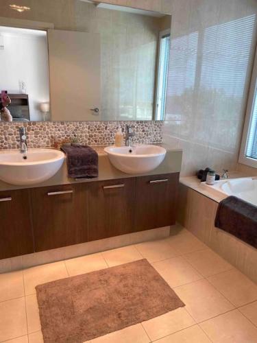 a bathroom with two sinks and a large mirror at Views on Hughes in Port Moonta