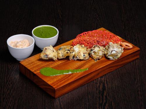 a plate of food with meatballs and sauce on a cutting board at Zone Connect by The Park Port Blair in Port Blair