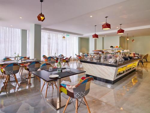 a restaurant with tables and chairs and a bar at Zone Connect by The Park Port Blair in Port Blair