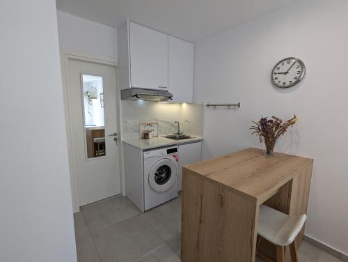 a kitchen with a table and a washing machine at Modern & Cozy Studio w/ Backyard Near City Center in Limassol