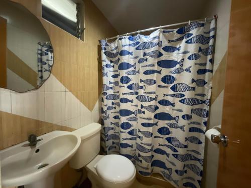 La salle de bains est pourvue de toilettes, d'un lavabo et d'un rideau de douche. dans l'établissement Balay Inato Pension, à Puerto Princesa