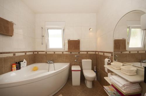a bathroom with a tub and a toilet and a sink at Apartment with pool near Split in Split