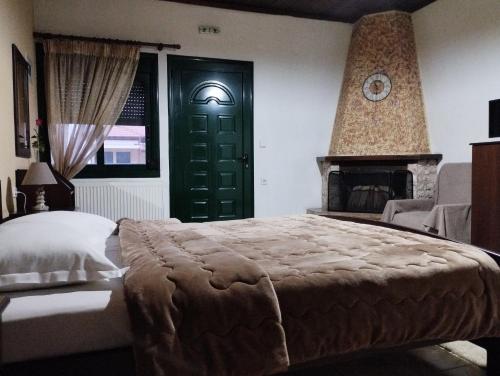 a bedroom with a large bed and a green door at Paradise Studios in Kato Loutraki