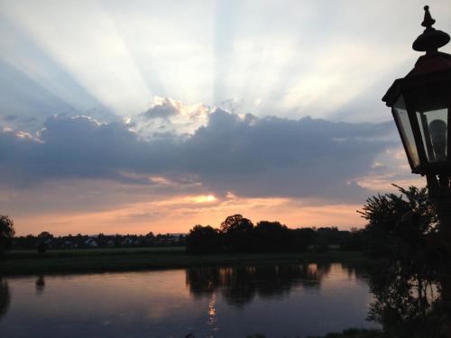 a sunset over a river with a street light at Pension Villa Else in Heidenau