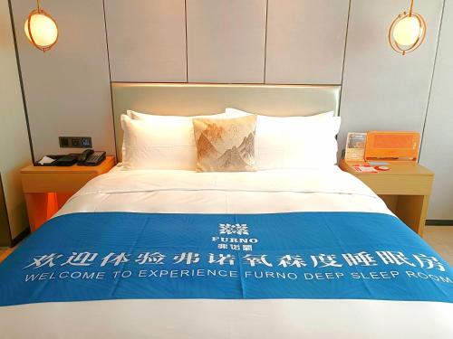 a bed in a hotel room with a sign on it at Qingyuan Argyle Hotel in Qingyuan