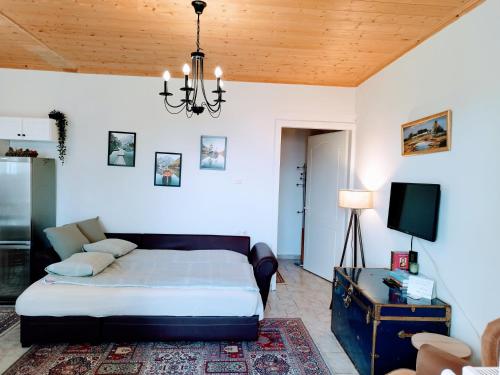 Cozy cottage for 4 في Lávdhas: غرفة نوم بسرير وثريا