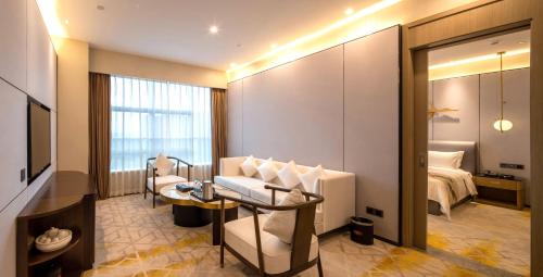 a hotel room with a bed and a television at Qingyuan Argyle Hotel in Qingyuan