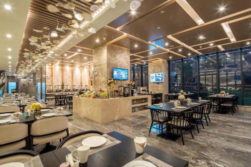 a restaurant with tables and chairs and a bar at Qingyuan Argyle Hotel in Qingyuan