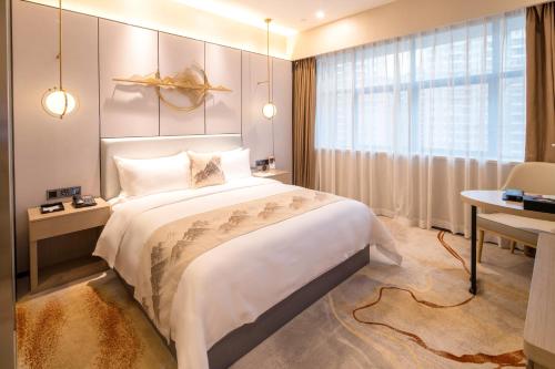 a bedroom with a large bed and a window at Qingyuan Argyle Hotel in Qingyuan