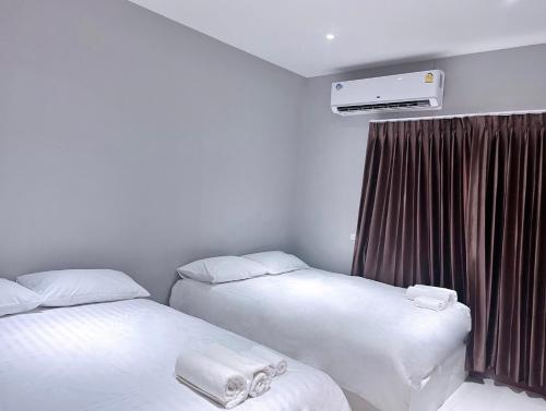 two beds in a hotel room with a heater at Aowmana Hotel in Makkasan