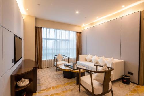 a hotel room with a couch and a table and a television at Qingyuan Argyle Hotel in Qingyuan