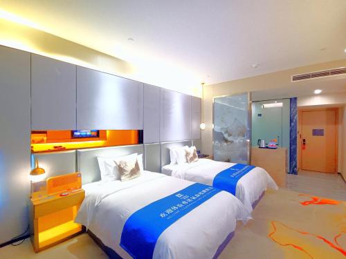 a hotel room with two beds in a room at Qingyuan Argyle Hotel in Qingyuan
