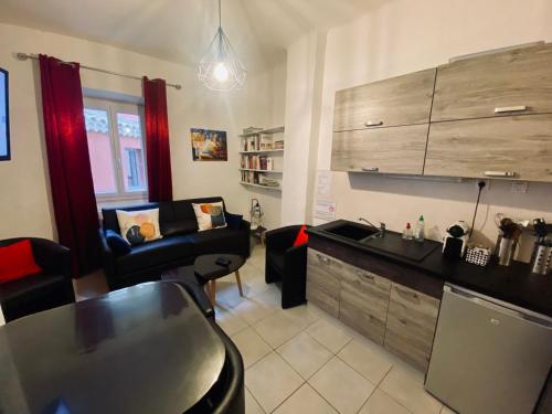 Una cocina y una sala de estar con un sofá y una mesa. en Casa Salon T2 Centre historique Wifi Climatisation, en Salon-de-Provence