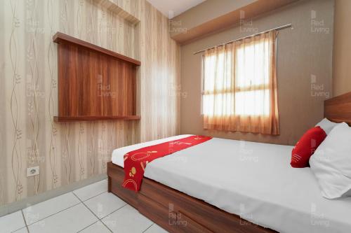 um quarto com uma cama com um cobertor vermelho em RedLiving Apartemen Mekarwangi Square - Agus 3 Tower A em Bandung