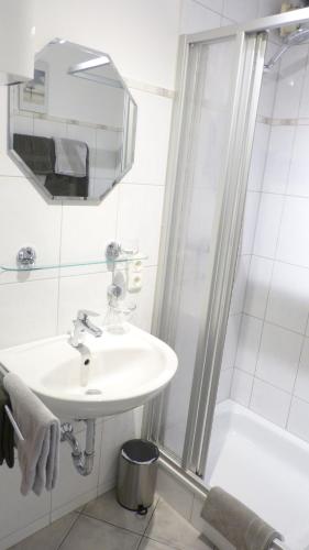 y baño blanco con lavabo y ducha. en Ferienappartments Neumann, en Bernkastel-Kues